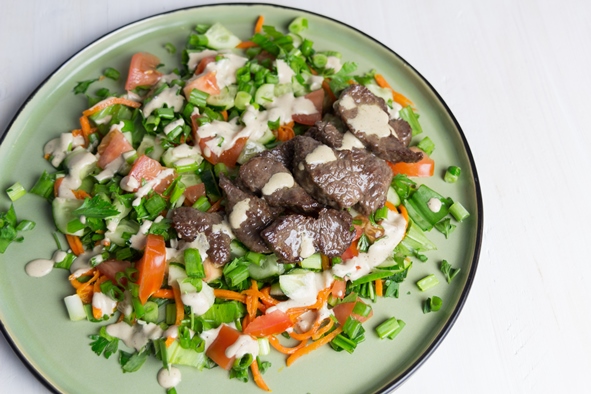 Салат из свежих овощей и жареной говядины и специями